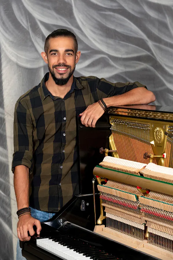 Roberto, profesor de piano, junto a su piano